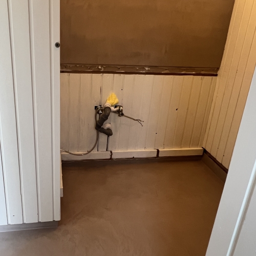 Gulv og væg i badeværelse dækket med microcement – resultat af solidt murerarbejde i Vestjylland.