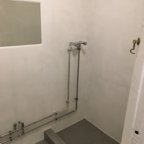 Efterbillede af badeværelse i Nørrebro med elegant silkecement finish – udført af professionel murer.