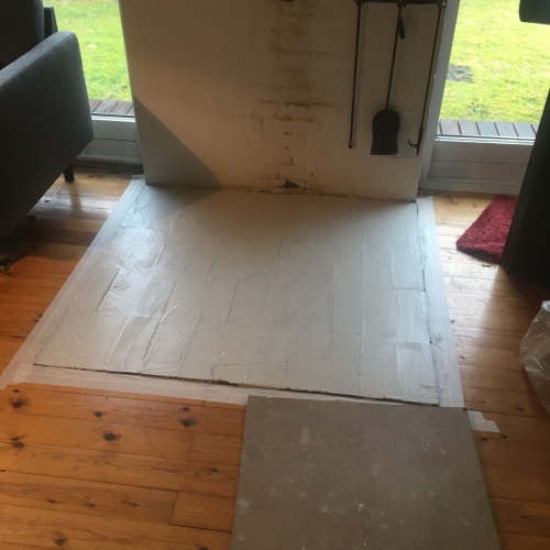 Område ved brændeovn forberedt til microcement – del af renovering i sommerhus i Nørre Nebel, Vestjylland.