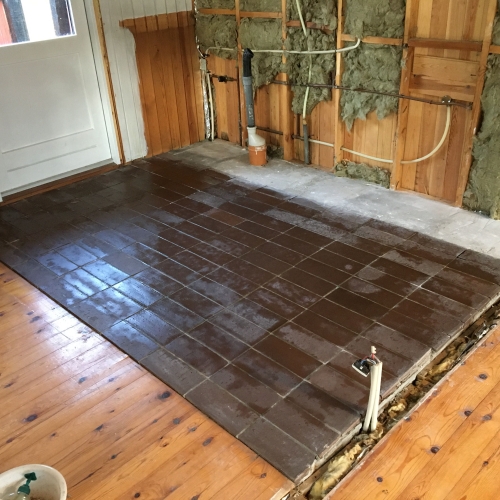 Ældre klinker på gulv i køkkenområde under renovering – microcement-forberedelse i sommerhus i Nørre Nebel i Vestjylland