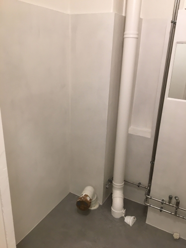 Renoveret badeværelse i Nørrebro med microcement – silkecement lagt af murer for moderne look.