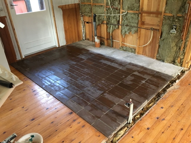 Ældre klinker på gulv i køkkenområde under renovering – microcement-forberedelse i sommerhus i Nørre Nebel i Vestjylland